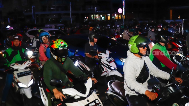 Pemudik bersepeda motor melintas di Jalan Inspeksi Kalimalang, Bekasi, Jawa Barat, Jumat (28/3/2025). [Suara.com/Alfian Winanto]