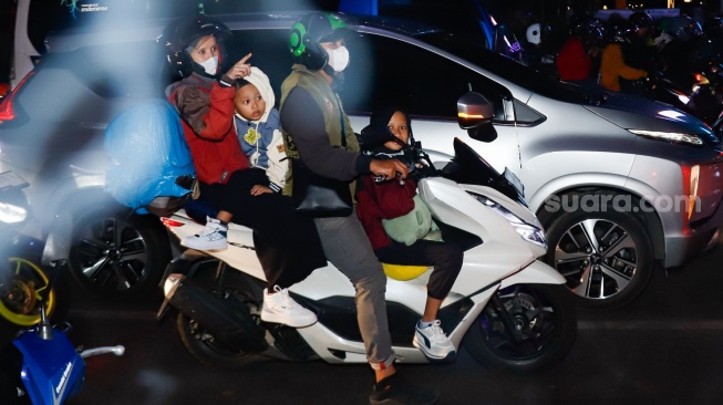 Pemudik bersepeda motor melintas di Jalan Inspeksi Kalimalang, Bekasi, Jawa Barat, Jumat (28/3/2025). [Suara.com/Alfian Winanto]