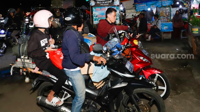 Pemudik bersepeda motor melintas di Jalan Inspeksi Kalimalang, Bekasi, Jawa Barat, Jumat (28/3/2025). [Suara.com/Alfian Winanto]