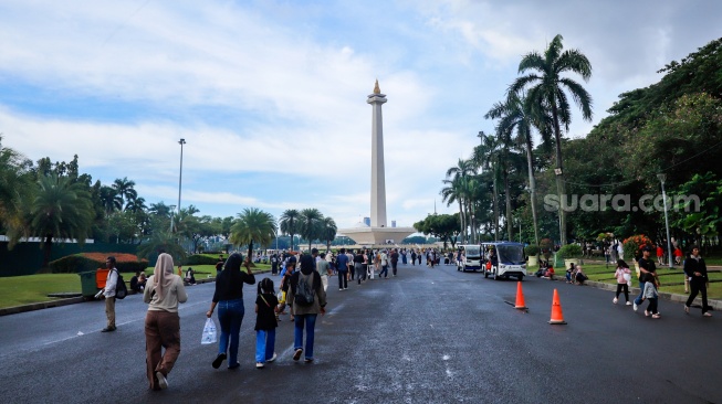 Warga berwisata di Monumen Nasional (Monas), Jakarta, Sabtu (5/4/2025). [Suara.com/Alfian Winanto]