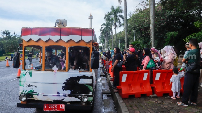 Warga berwisata di Monumen Nasional (Monas), Jakarta, Sabtu (5/4/2025). [Suara.com/Alfian Winanto]