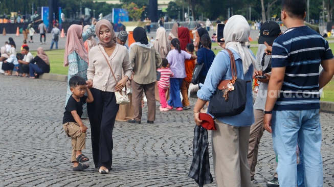 Warga berwisata di Monumen Nasional (Monas), Jakarta, Sabtu (5/4/2025). [Suara.com/Alfian Winanto]