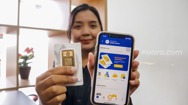 Petugas menunjukan emas Antam di Butik Emas Logam Mulia Antam, TB Simatupang, Jakata (14/4/2025). [Suara.com/Alfian Winanto]