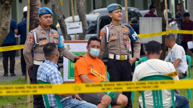 Aiptu KS (kedua kiri) anggota Polri yang ditetapkan tersangka perjudian sabung ayam oleh Polda Lampung turut dihadirkan sebagai saksi saat rekonstruksi penembakan tiga polisi anggota Polisi Polsek Negara Batin Way Kanan di lapangan Satlog Satdisjan Korem 043/Garuda Hitam Lampung, Lampung, Kamis (17/4/2025). [ANTARA FOTO/Ardiansyah/foc]