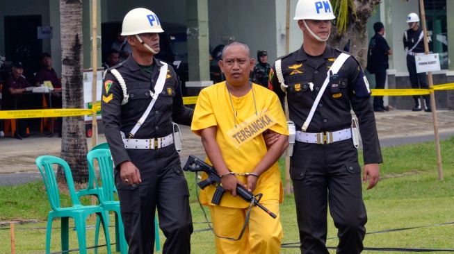 Polisi Militer mengawal tersangka kasus penembakan tiga polisi anggota Polisi Polsek Negara Batin Way Kanan, saat rekonstruksi di lapangan Satlog Satdisjan Korem 043/Garuda Hitam Lampung, Lampung, Kamis (17/4/2025).  [ANTARA FOTO/Ardiansyah/foc]