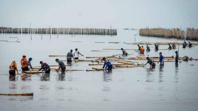 Petugas gabungan bersama nelayan mengumpulkan bambu dari pembongkaran pagar laut di pesisir laut Desa Kohod, Kabupaten Tangerang, Banten, Kamis (17/4/2025). [ANTARA FOTO/Putra M. Akbar/nym]