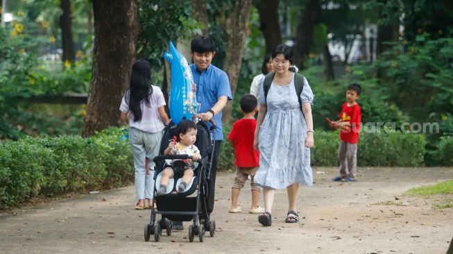 Sejumlah warga saat berwisata di Tebet Eco Park, Tebet, Jakarta, Jumat (18/4/2025). [Suara.com/Alfian Winanto]
