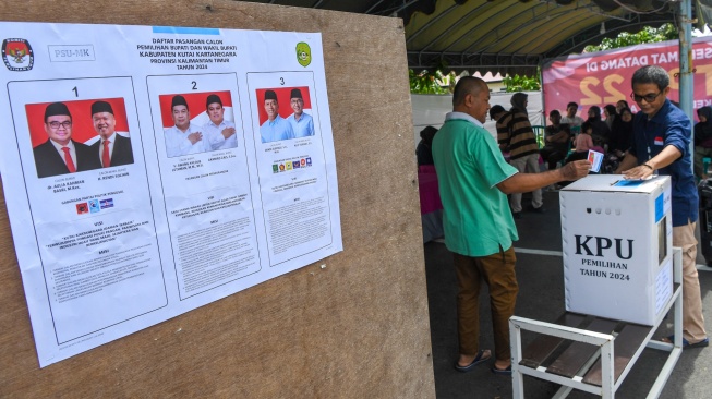 Warga memasukkan surat suara ke dalam kotak suara saat pemungutan suara ulang Pilkada Kabupaten Kutai Kartanegara di TPS 22 Arwana di Tenggarong, Kutai Kartanegara, Kalimantan Timur, Sabtu (19/4/2025). [ANTARA FOTO/M Risyal Hidayat/agr]