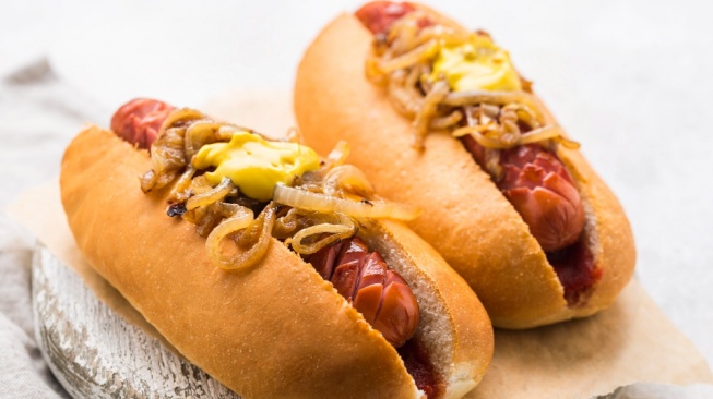 Ilustrasi hot dog - daging olahan menjadi salah satu makanan yang dapat meningkatkan risiko kanker (Freepik)