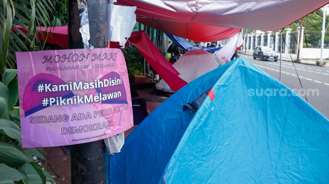 Sejumlah aktivis beraktivitas di dalam tenda dalam kegiatan Piknik Melawan di Depan Gerbang Pancasila DPR RI, Jakarta, Senin (21/4/2025). [Suara.com/Alfian Winanto]