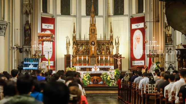 Sejumlah umat Katolik mengikuti misa untuk mendiang Paus Fransiskus di Gereja Katedral Jakarta, Senin (21/4/2024). [Suara.com/Alfian Winanto]