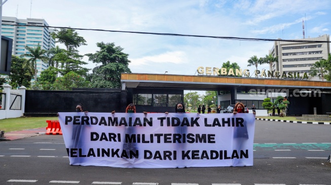 Sejumlah aktivis perempuan membentangkan spanduk tuntutan saat aksi Piknik Melawan di Depan Gerbang Pancasila DPR RI, Jakarta, Senin (21/4/2025). [Suara.com/Alfian Winanto]