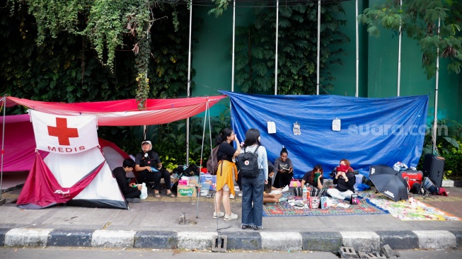 Sejumlah aktivis beraktivitas di dalam tenda dalam kegiatan Piknik Melawan di Depan Gerbang Pancasila DPR RI, Jakarta, Senin (21/4/2025). [Suara.com/Alfian Winanto]