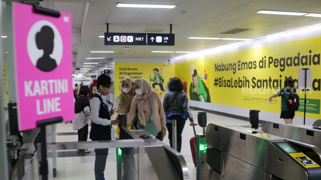 Penumpang perempuan berada di dalam kereta MRT di Stasiun Bundaran HI, Jakarta, Senin (21/4/2025). [Suara.com/Alfian Winanto]