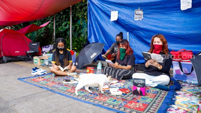 Sejumlah aktivis beraktivitas di dalam tenda dalam kegiatan Piknik Melawan di Depan Gerbang Pancasila DPR RI, Jakarta, Senin (21/4/2025). [Suara.com/Alfian Winanto]