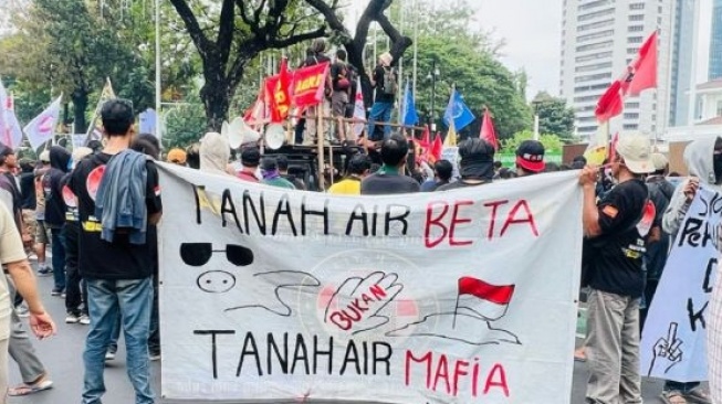 Sebagian massa aksi tampak membawa beberapa poster yang antara lain bertuliskan "Tanah Air Beta Tanah Air Mafia" dan "Stop Penggusuran dan Perusak Lingkungan di Wilayah Kebon Sayur". (Antara)
