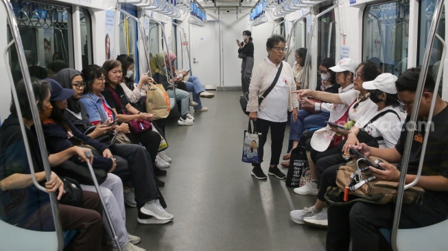Penumpang perempuan berada di dalam kereta MRT di Stasiun Bundaran HI, Jakarta, Senin (21/4/2025). [Suara.com/Alfian Winanto]