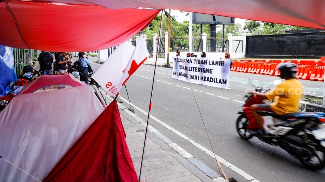 Sejumlah aktivis beraktivitas di dalam tenda dalam kegiatan Piknik Melawan di Depan Gerbang Pancasila DPR RI, Jakarta, Senin (21/4/2025). [Suara.com/Alfian Winanto]