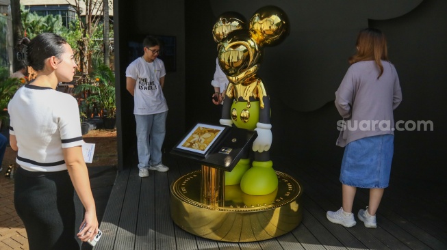 Pengunjung melihat karya instalasi seni pada Pameran Art Jakarta Gardens di Hutan Kota Plataran, Senayan, Jakarta, Jumat (25/4/2025). [Suara.com/Alfian Winanto]