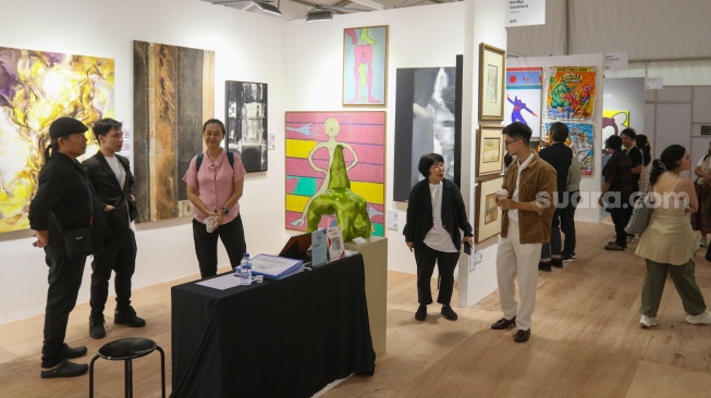 Pengunjung melihat karya instalasi seni pada Pameran Art Jakarta Gardens di Hutan Kota Plataran, Senayan, Jakarta, Jumat (25/4/2025). [Suara.com/Alfian Winanto]