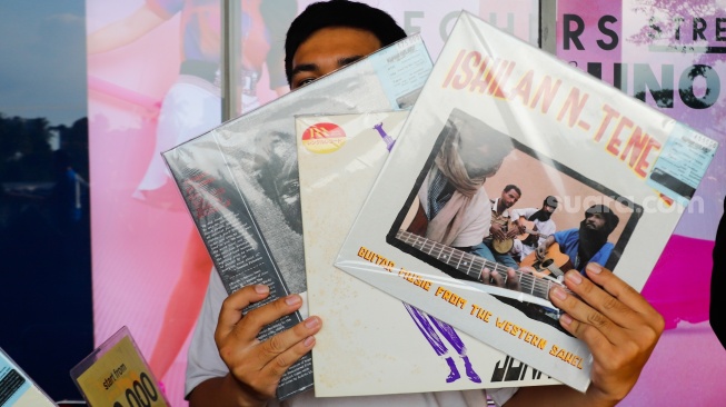 Pengunjung memilih rilisan fisik yang ditawarkan dalam acara Record Store Day Indonesia x Pop City di Senayan Park, Jakarta, Jumat (25/4/2025). [Suara.com/Alfian Winanto] 