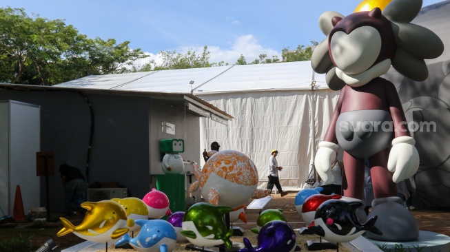 Pengunjung melihat karya instalasi seni pada Pameran Art Jakarta Gardens di Hutan Kota Plataran, Senayan, Jakarta, Jumat (25/4/2025). [Suara.com/Alfian Winanto]