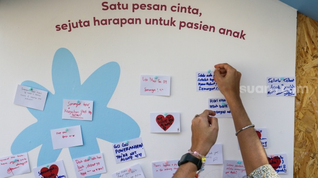 Pengunjung melihat karya instalasi seni pada Pameran Art Jakarta Gardens di Hutan Kota Plataran, Senayan, Jakarta, Jumat (25/4/2025). [Suara.com/Alfian Winanto]