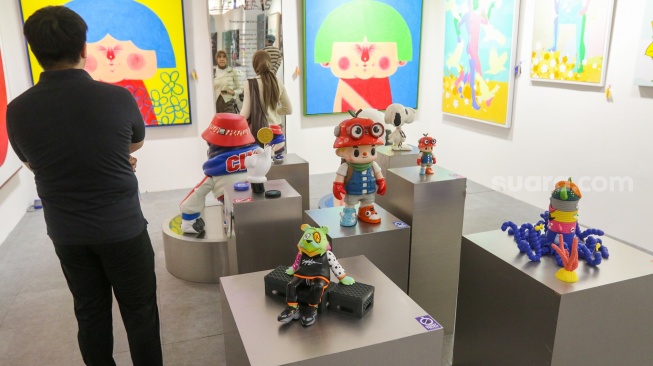 Pengunjung melihat karya instalasi seni pada Pameran Art Jakarta Gardens di Hutan Kota Plataran, Senayan, Jakarta, Jumat (25/4/2025). [Suara.com/Alfian Winanto]