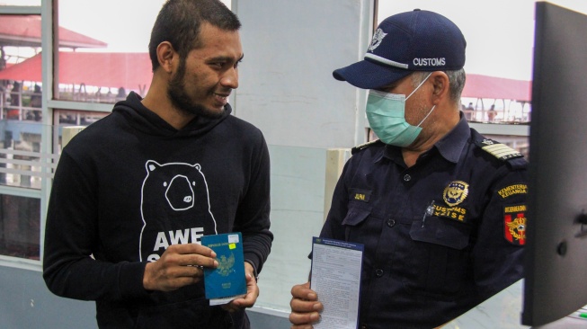 Petugas bea cukai (kanan) memeriksa dokumen seorang warga negara Indonesia (WNI) yang dideportasi dari Malaysia di Terminal Pelabuhan Pelindo Dumai, Riau, Senin (28/4/2025). [ANTARA FOTO/Aswaddy Hamid/tom]