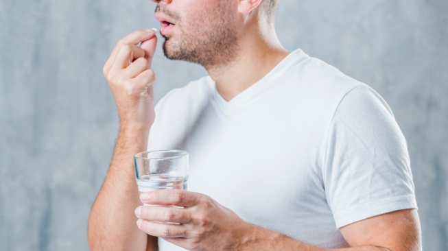 ilustrasi pria minum obat (freepik)