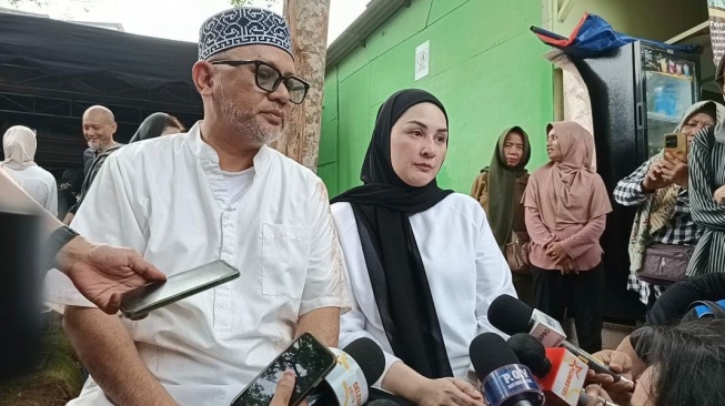 Mona Ratuliu dan suaminya, Indra Brasco di TPU Jeruk Purut, Jakarta Selatan pada Kamis, 1 Mei 2025. [Suara.com/Rena Pangesti]