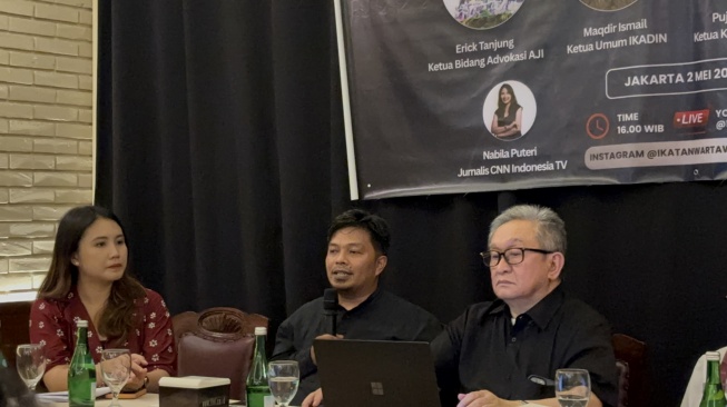 Ketua Bidang Advokasi Aliansi Jurnalis Indonesia (AJI), Ercik Tanjung (tengah) dan pengacara Maqdir Ismail. (Suara.com/Dea)