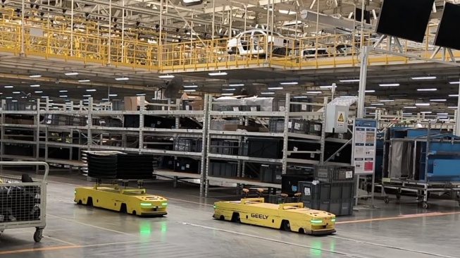 Robot-robot bekerja di Geely Auto Changxing Base, pabrik berteknologi tinggi dan ramah lingkungan Geely di Tiongkok. Pabrik ini yang bisa memproduksi 400 ribu unit mobil per tahun. [Suara.com/Liberty Jemadu]