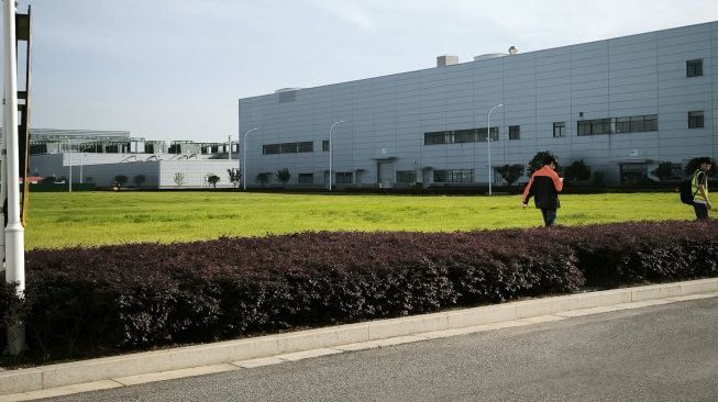 Hamparan rumput dan bunga di Geely Auto Changxing Base, pabrik berteknologi tinggi dan ramah lingkungan Geely di Tiongkok. Pabrik ini bisa memproduksi 400 ribu unit mobil per tahun. [Suara.com/Liberty Jemadu]