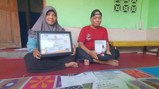 Ayah Shafira, Erliyansah dan sang ibu Revi Rochana, menunjukkan sejumlah prestasi sang buah hati di Sleman. [Hiskia/Suarajogja]