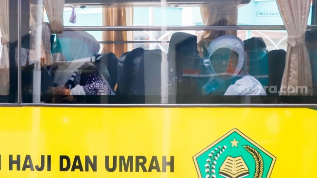 Calon jamaah haji menaiki bus usai melakukan pendataan di Asrama Haji Pondok Gede, Jakarta, Senin (5/5/2025). [Suara.com/Alfian Winanto]
