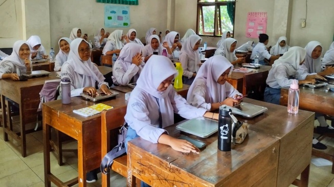 Para siswa mendapatan menu MBG di SMKN 4 Yogyakarta, Senin(5/5/2025). [Kontributor/Putu]