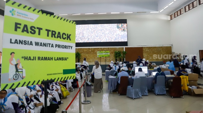 Petugas melakukan pendataan calon jamaah haji di Asrama Haji Pondok Gede, Jakarta, Senin (5/5/2025). [Suara.com/Alfian Winanto]
