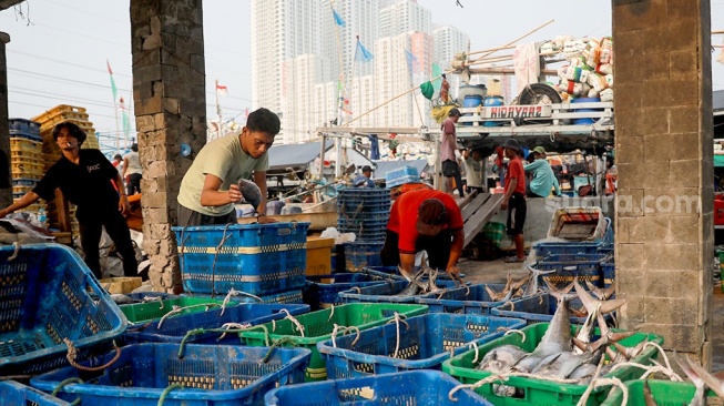 Pekerja melakukan bongkar muat ikan di Dermaga Pelabuhan Muara Angke, Jakarta, Selasa (6/5/2025). [Suara.com/Alfian Winanto]