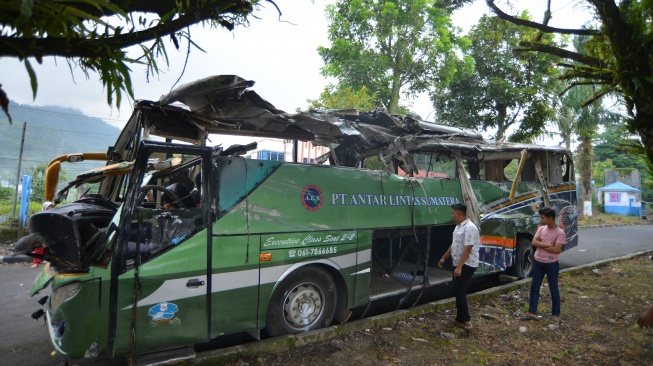 Warga melihat kondisi Bus ALS (Antar Lintas Sumatera) yang hancur akibat kecelakaan di Padang Panjang, Sumatera Barat, Selasa (6/5/2025). [ANTARA FOTO/Iggoy el Fitra/bar]