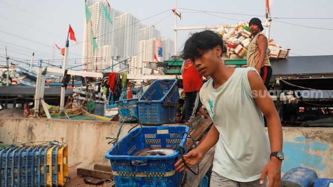 Pekerja melakukan bongkar muat ikan di Dermaga Pelabuhan Muara Angke, Jakarta, Selasa (6/5/2025). [Suara.com/Alfian Winanto]