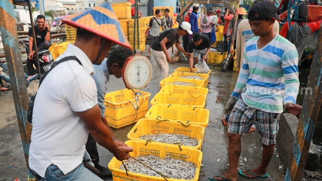 Pekerja melakukan bongkar muat ikan di Dermaga Pelabuhan Muara Angke, Jakarta, Selasa (6/5/2025). [Suara.com/Alfian Winanto]