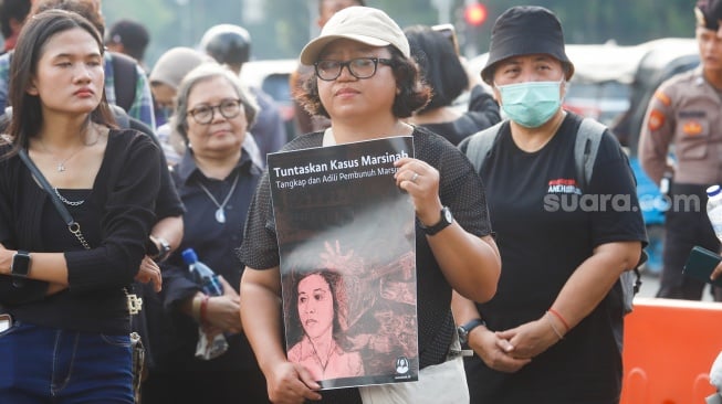 Aktivis Jaringan Solidaritas Korban untuk Keadilan membawa poster Marsinah saat mengikuti aksi Kamisan ke-860 di depan Istana Merdeka, Jakarta, Kamis (8/5/2025). [Suara.com/Alfian Winanto]