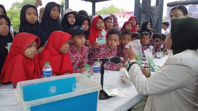Anak-anak diberi penjelasan oleh salah satu dokter pada pengobatan gratis sebagai rangkaian acara perayaan Waisak di Candi Borobudur. (Suara.com/ Angga Haksoro A). 