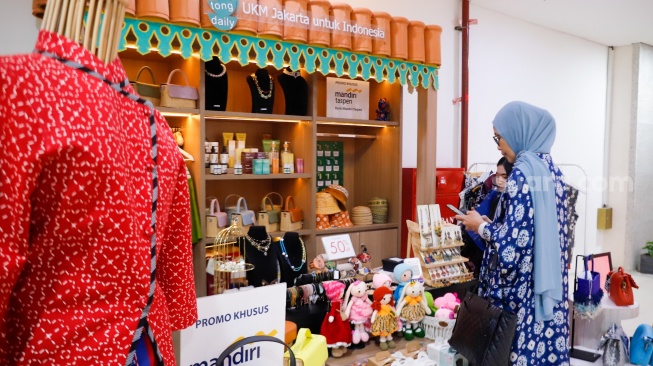 Pembeli memindai Kode Respons Cepat Standar (QRIS) di Sarinah, Jakarta, Selasa (13/5/2025). [Suara.com/Alfian Winanto]