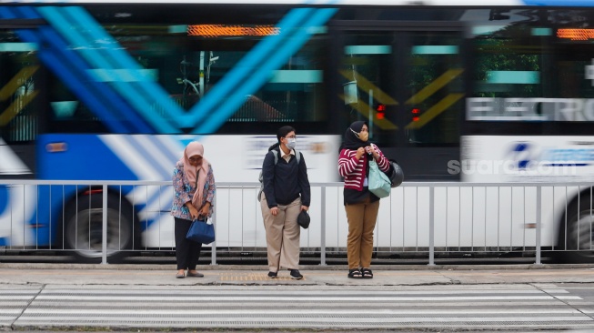 Pekerja berjalan sepulang bekerja di kawasan Jalan MH Thamrin, Jakarta, Rabu (14/5/2025). [Suara.com/Alfian Winanto]