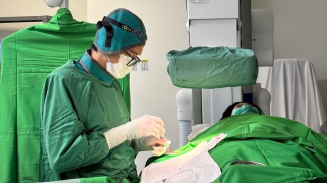 DR. dr. Sidhi Laksono, Sp.JP, Subsp.KI(K), FIHA, MARS, MH, CPHM, FISQUA dokter spesialis jantung dan pembuluh darah subspesialis kardiologi intervensi di RS Siloam Jantung Diagram saat sedang melakukan tindakan medis. [ANTARA/HO]