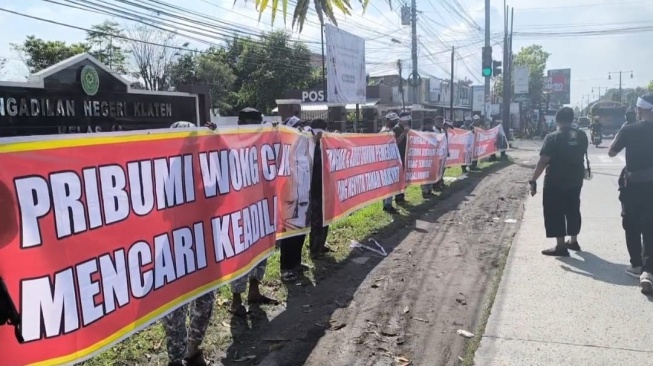 Puluhan orang menggeruduk PN Klaten dan membentangkan sejumlah spanduk untuk mendukung salah seorang warga dalam gugatan sengketa tanah, Kamis (15/5/2025) pagi. [Suara.com/istimewa]
