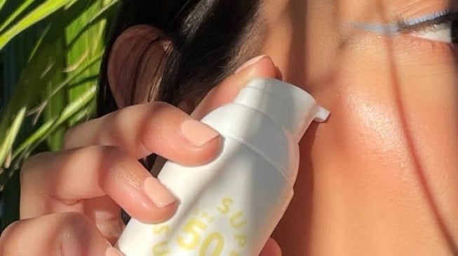 Ilustrasi wanita memakai sunscreen dengan SPF 50 di wajah. [Pexels/Sunny Skin]