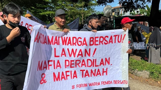 Warga Perumahan Gubernur dan Perumahan Pemda Kelurahan Manggala, Kota Makassar, menggelar unjuk rasa menolak mafia tanah dan mafia peradilan, Minggu 18 Mei 2025 [SuaraSulsel.id/Muhammad Yunus]